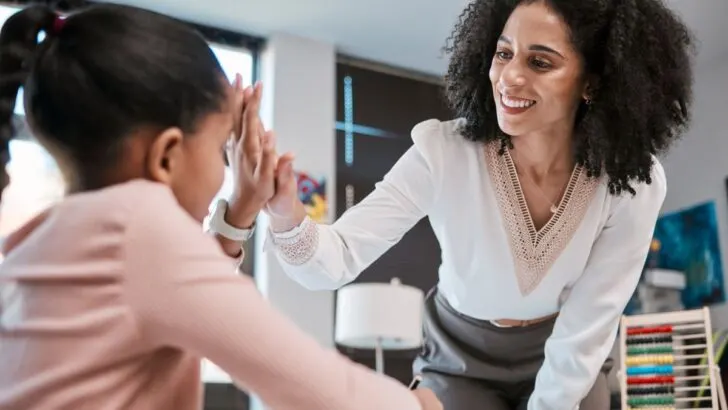 woman teacher giving high five to goal setting girl student