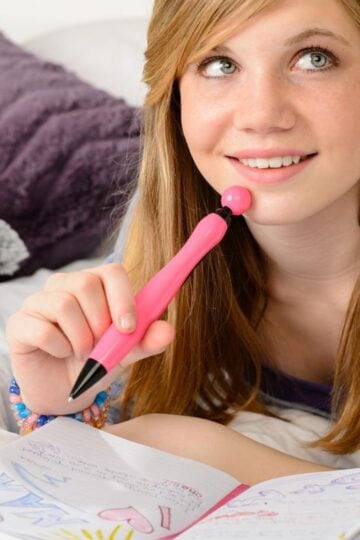 teen girl smiling looking into the sky, on her bed