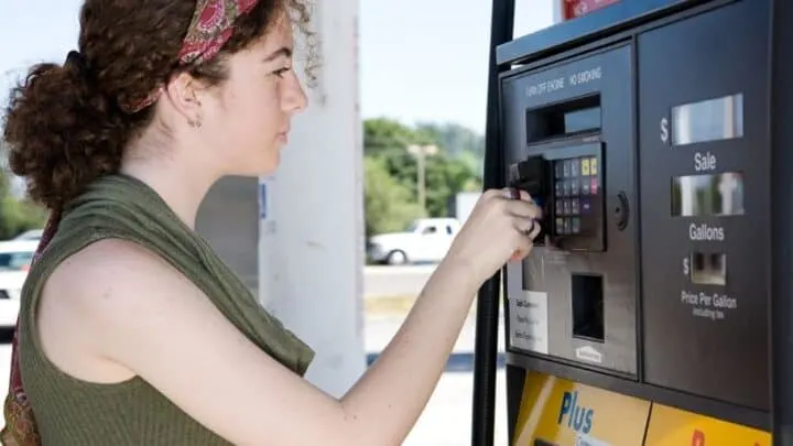 teenager using a debt card for kids at the gas pump