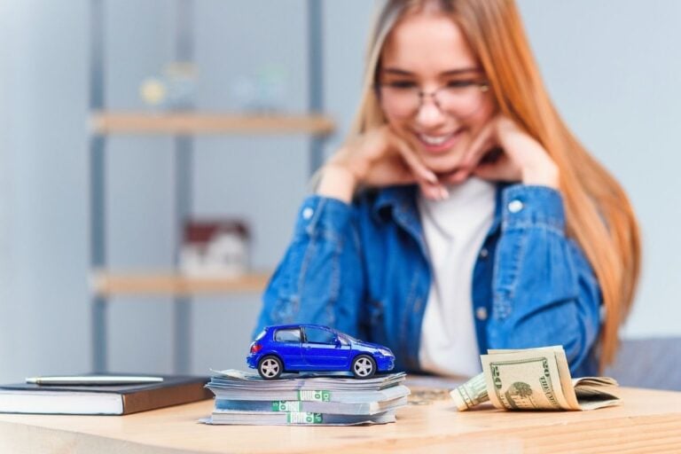teen girl smiling at car savings pile