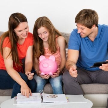mom, dad, and daughter on couch calculating allowance amount