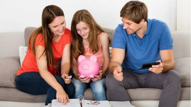 mom, dad, and daughter on couch calculating allowance amount