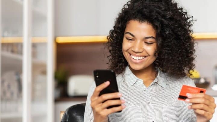 teen girl with prepaid debit card and phone, smiling