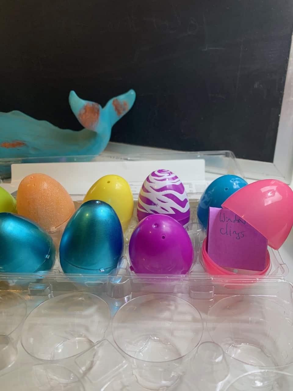 egg carton filled with a dozen Easter eggs, one open with an activity written on a little note