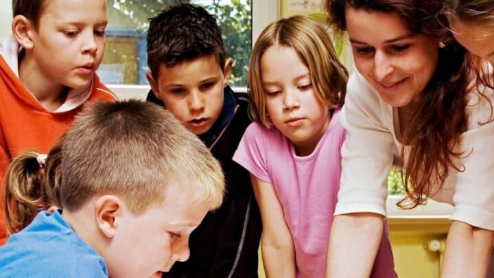 group of middle school students around table working on budget project