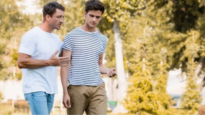 teen boy with father, walking in park, talking about a money problem
