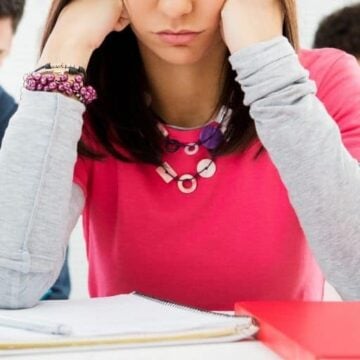 teenage girl with head in hands, thinking about her teenage financial problems