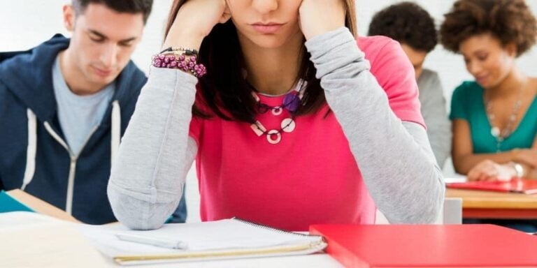 teenage girl with head in hands, thinking about her teenage financial problems