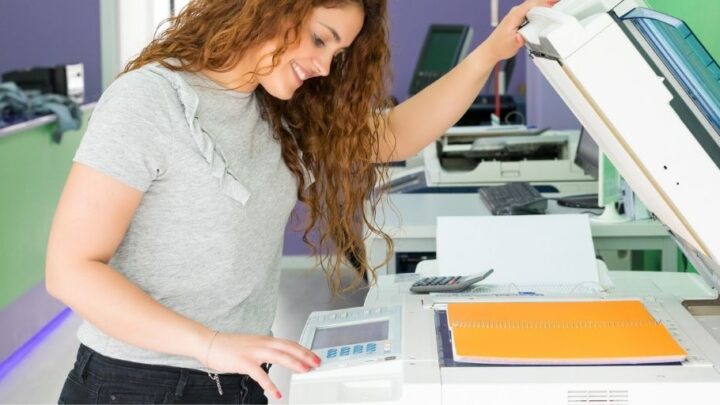 teen girl making photocopies and smiling, at her first teen job
