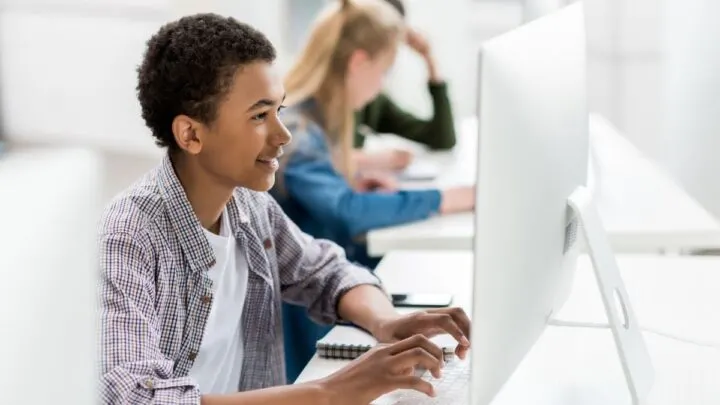 teen boy looking at computer screen while creating teen resume for first job