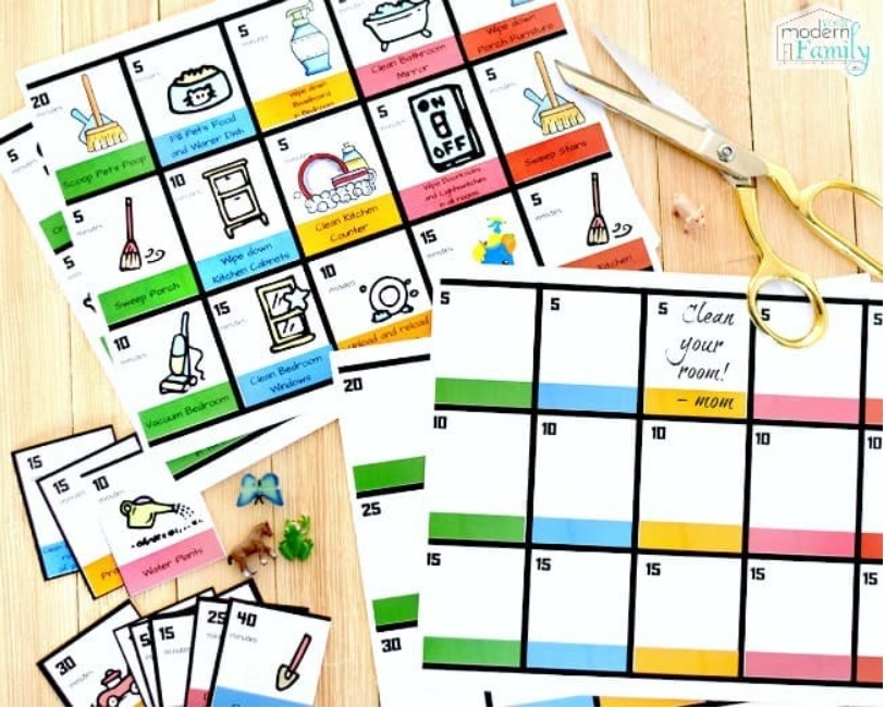 green, blue, yellow, pink, and red picture chore card set on wooden table