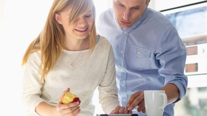 teen girl with father, helping her on iPhone with her money habits for students