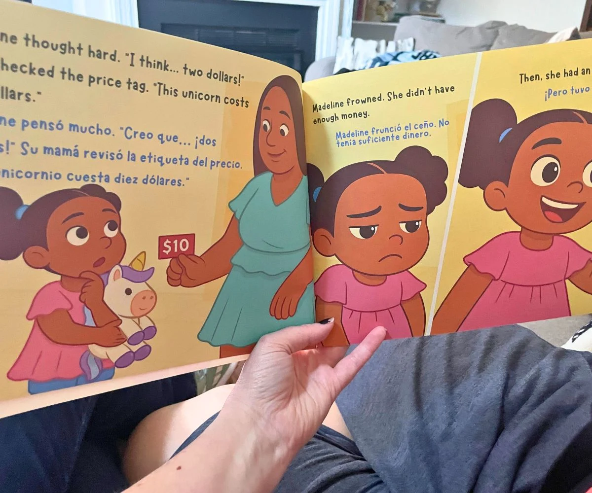 blogger reading Madeline's Money Adventure to son on couch