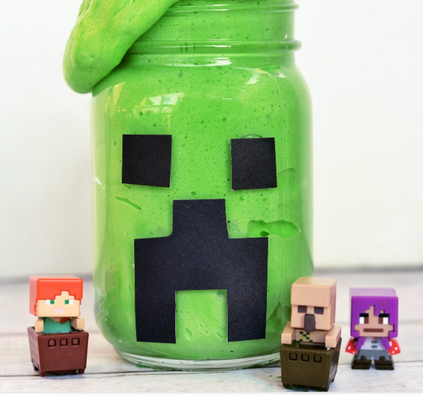large mason jar with bright green slime and black minecraft face glued on
