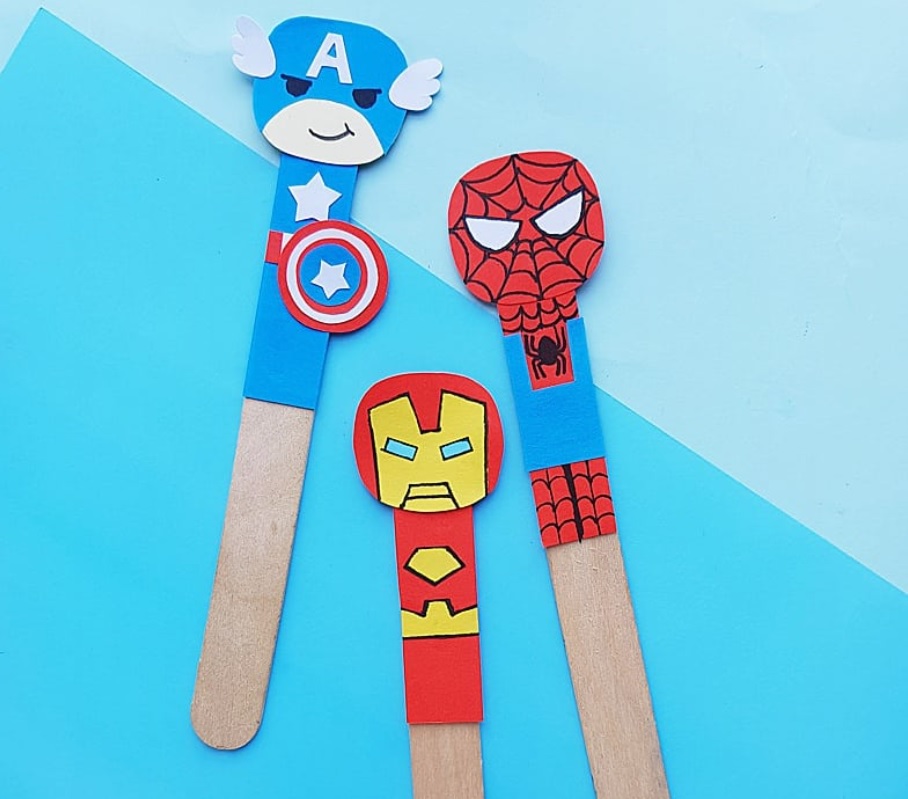 three popsicles with colorful yellow, red, and blue superhero faces on top
