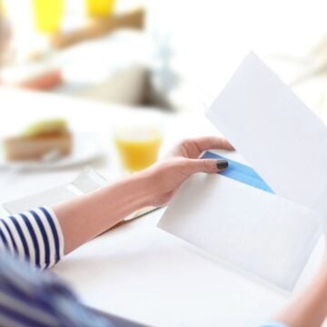 girl teenager in striped shirt taking money challenge out of envelope