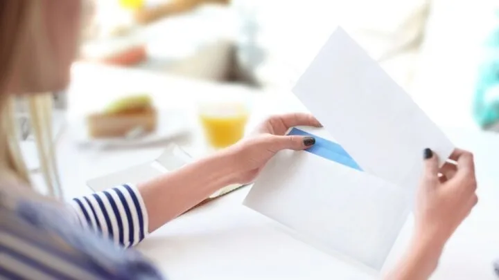 girl teenager in striped shirt taking money challenge out of envelope