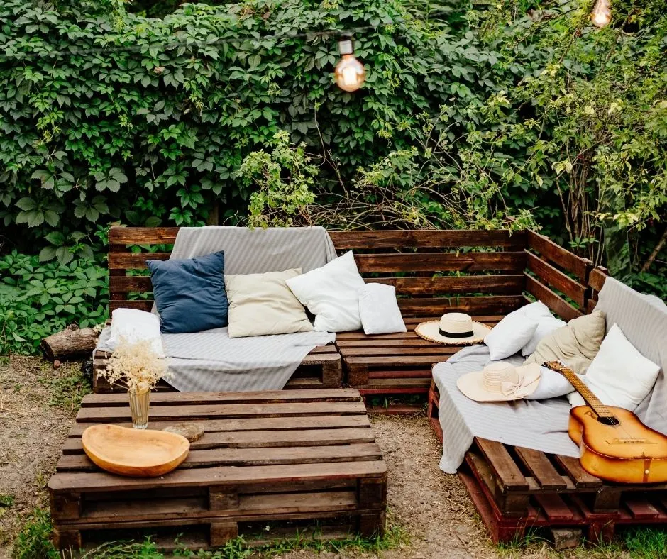 hangout area in backyard with pillows, blankets, and a guitar