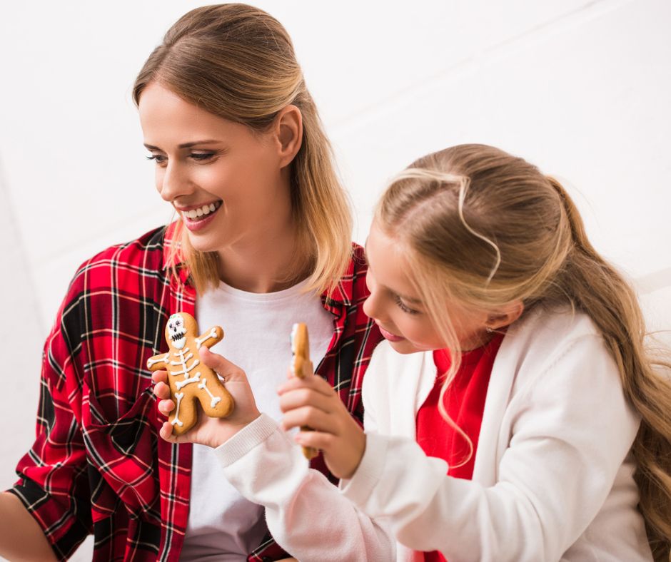 woman and daughter with skeleton gingerbread cookies, in red plaid