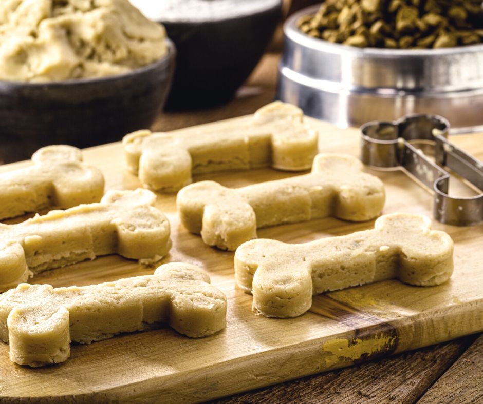 wood cutting board of homemade doggie thanksgiving biscuits and dog-bone cookie cutter