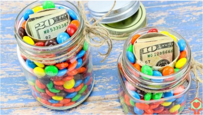 two mason jars of M&Ms with money in the inside of it, inside tubes