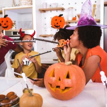 family enjoying halloween activity on family night with pumpkins, witch hats, and more