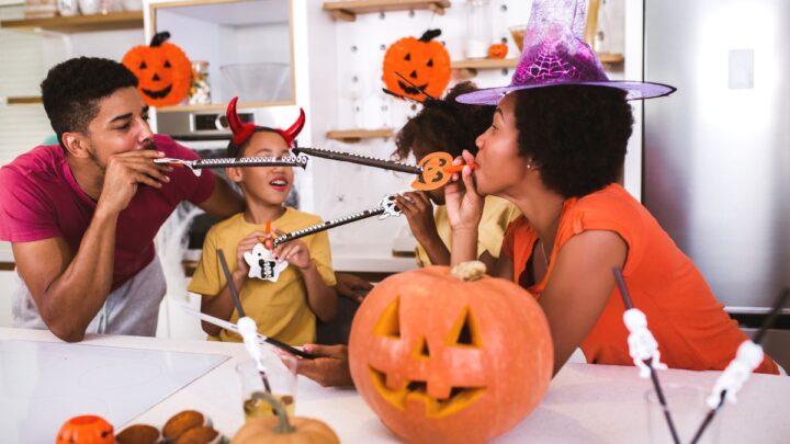 family enjoying halloween activity on family night with pumpkins, witch hats, and more