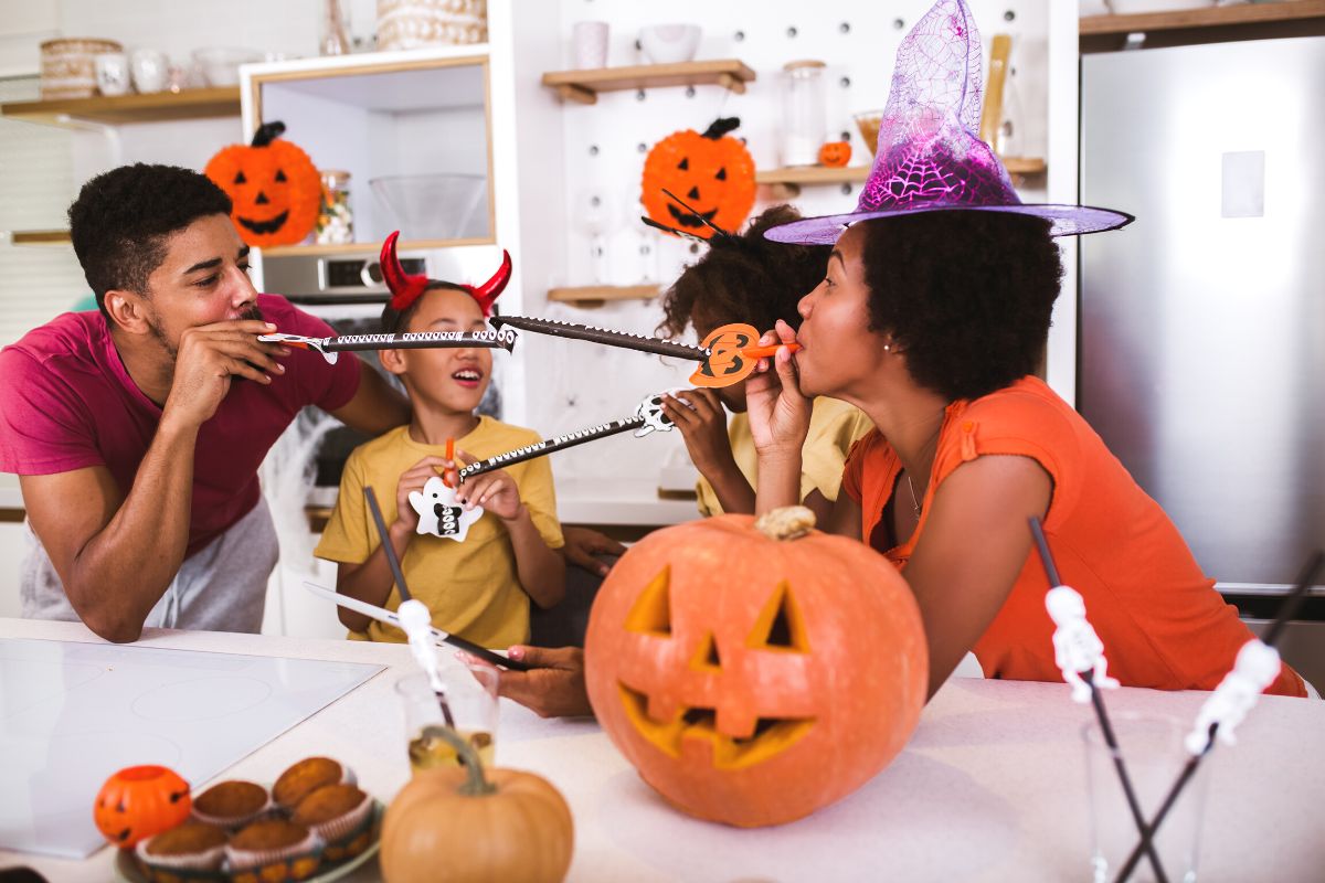family enjoying halloween activity on family night with pumpkins, witch hats, and more