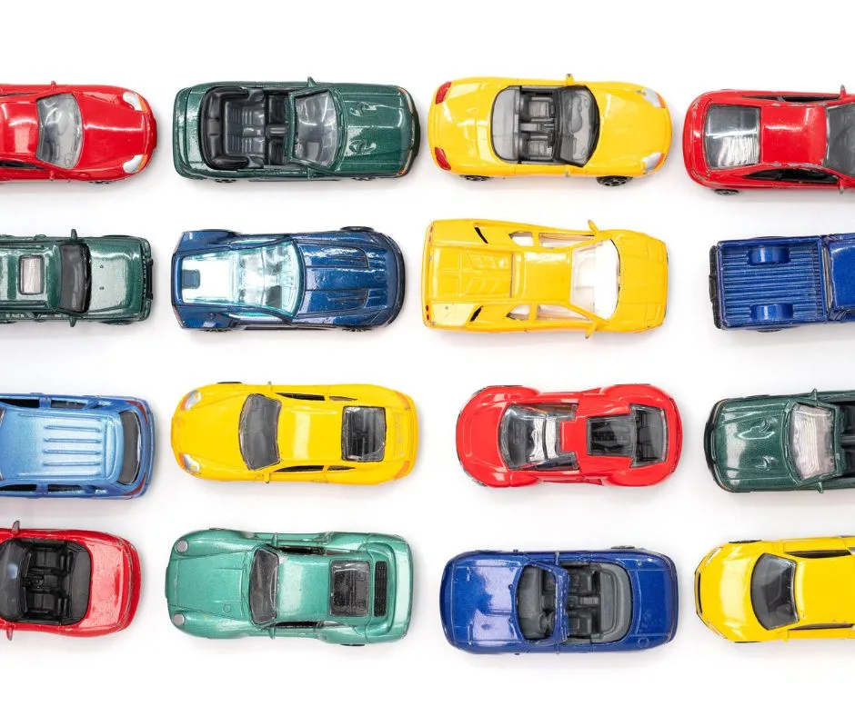 colorful matchbox cars lined up in rows on white background