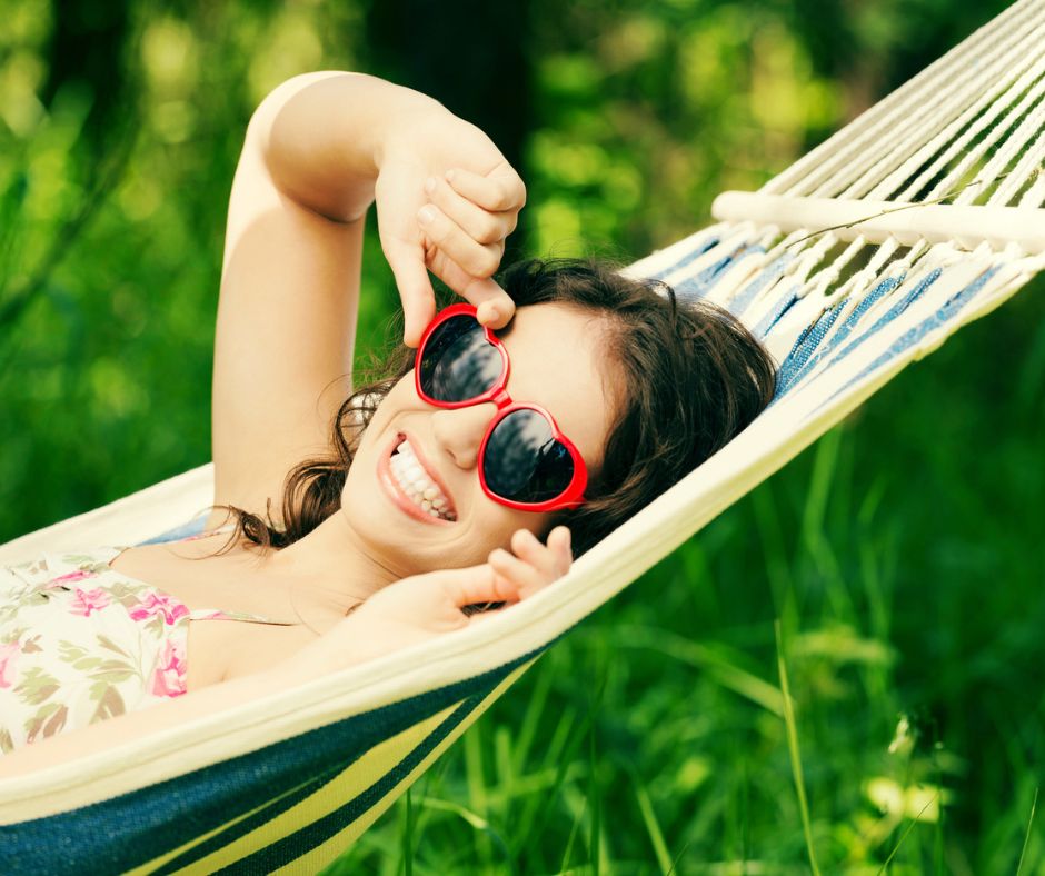 tween girl in hammock, smiling, with heart sunglasses on