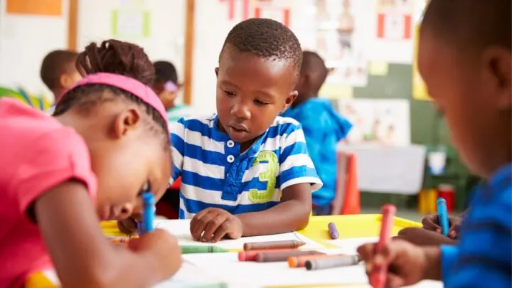 group of kindergarten students at table doing worksheets