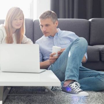 teen girl with father looking at white laptop, paypal account