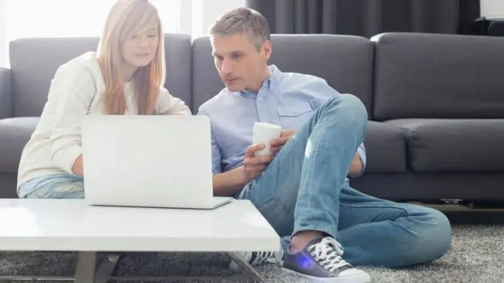 teen girl with father looking at white laptop, paypal account