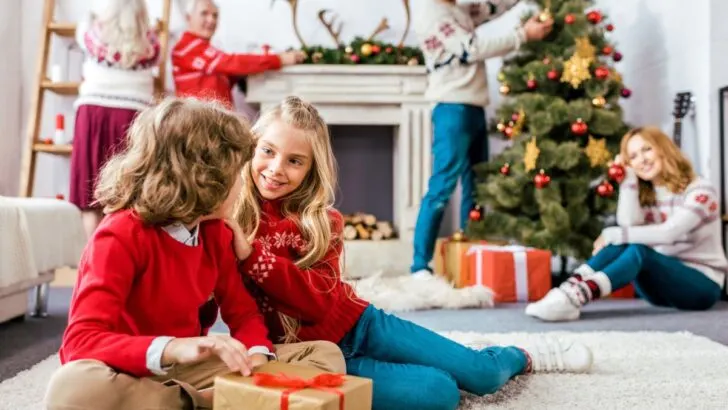 two kids doing Christmas activities with family in background, smiling