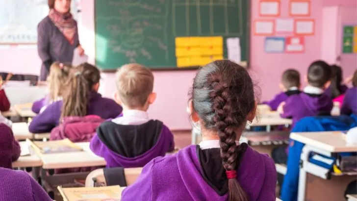 middle school students backs looking up at teacher