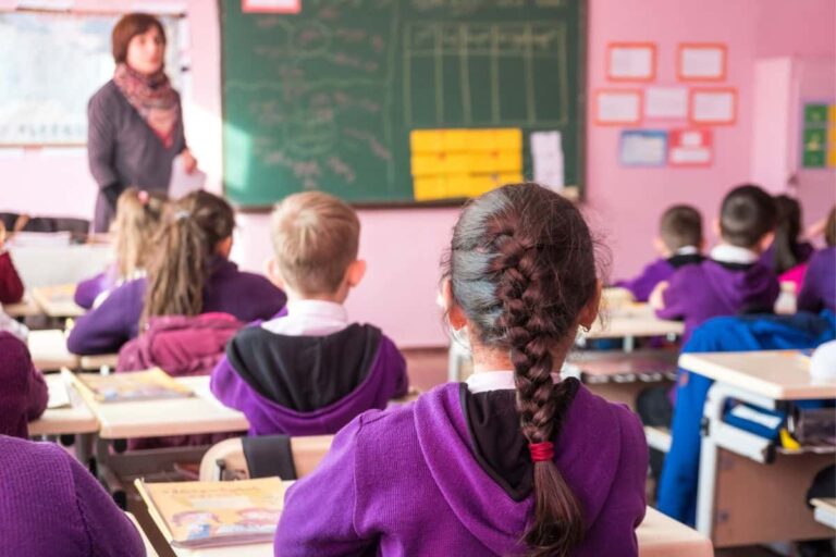 middle school students backs looking up at teacher
