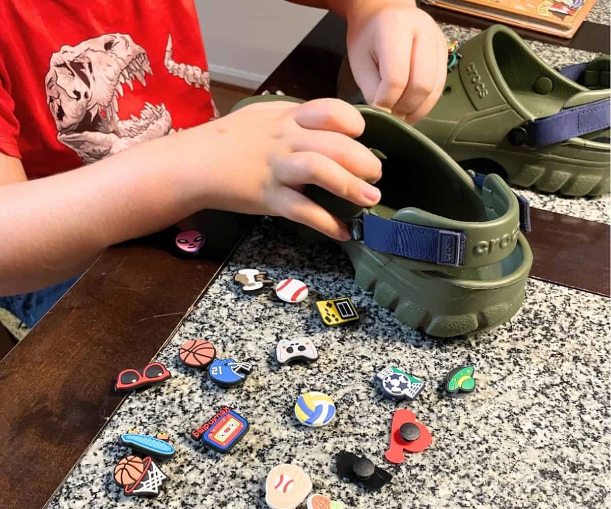 student putting shoe charms into his Crocs