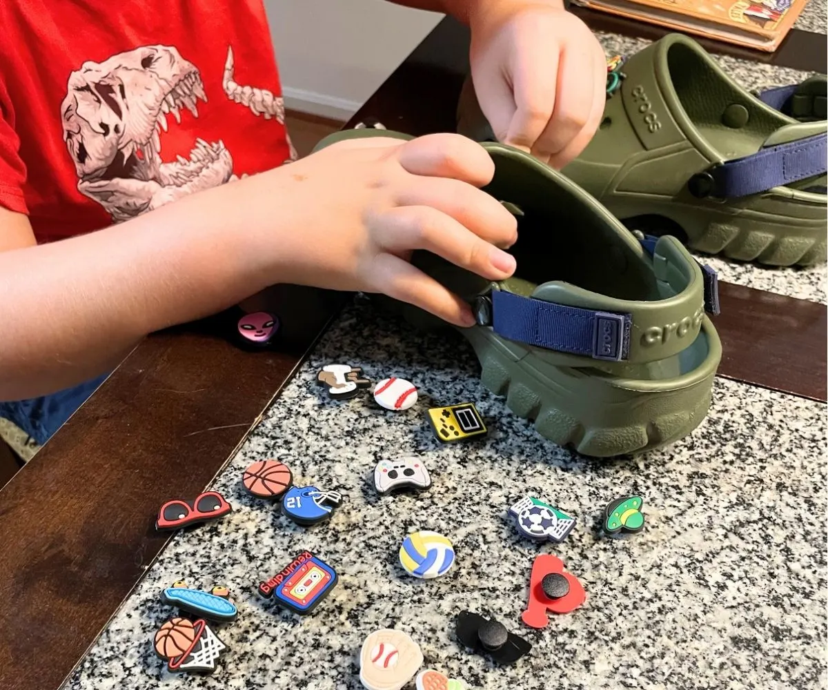 student putting shoe charms into his Crocs