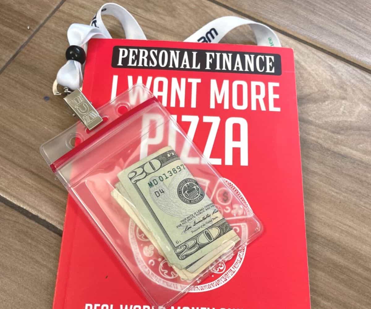 red I Want More Pizza book with employee badge on front with $20 inside