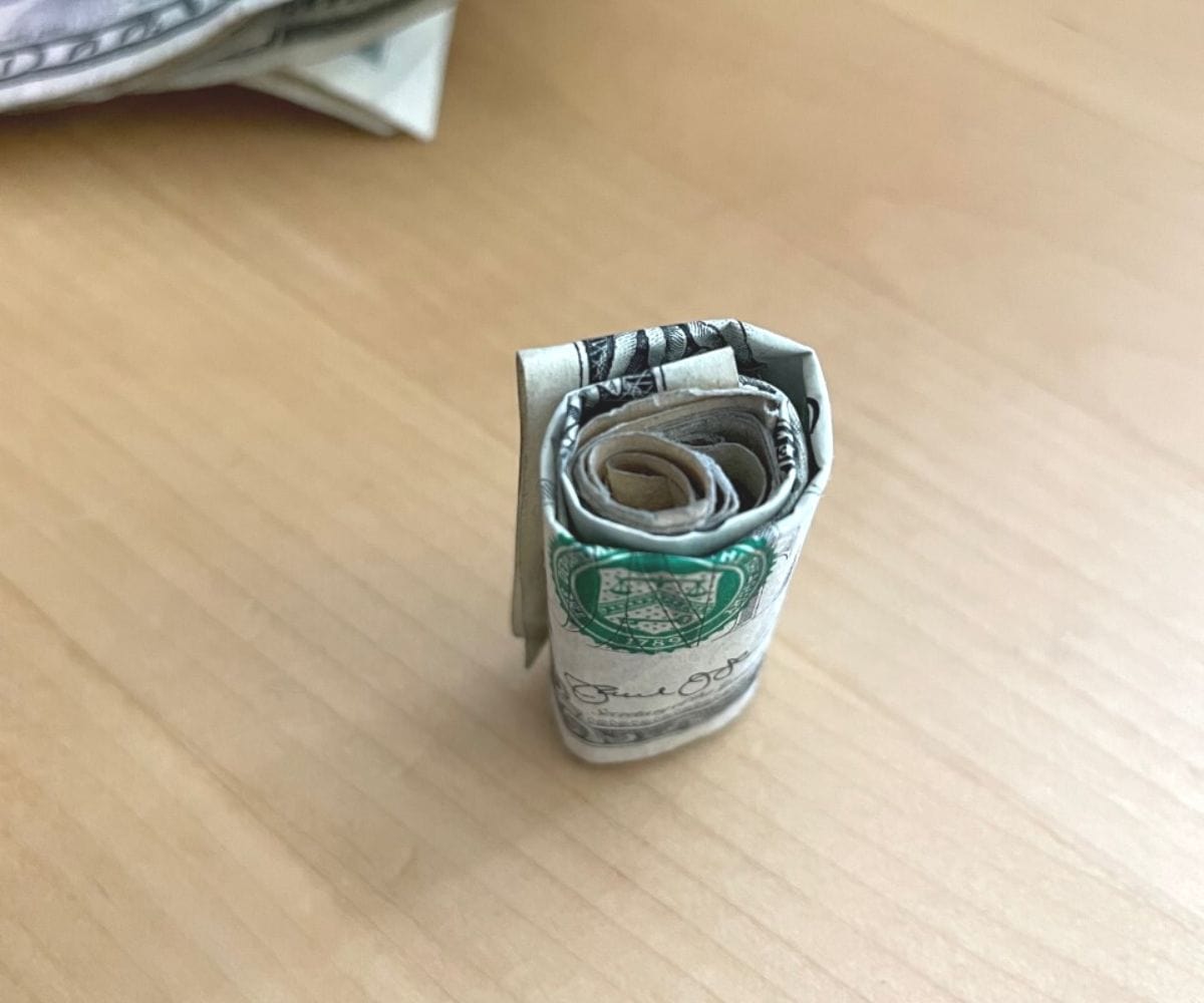 full money sushi roll done, standing straight up, with paper clips underneath