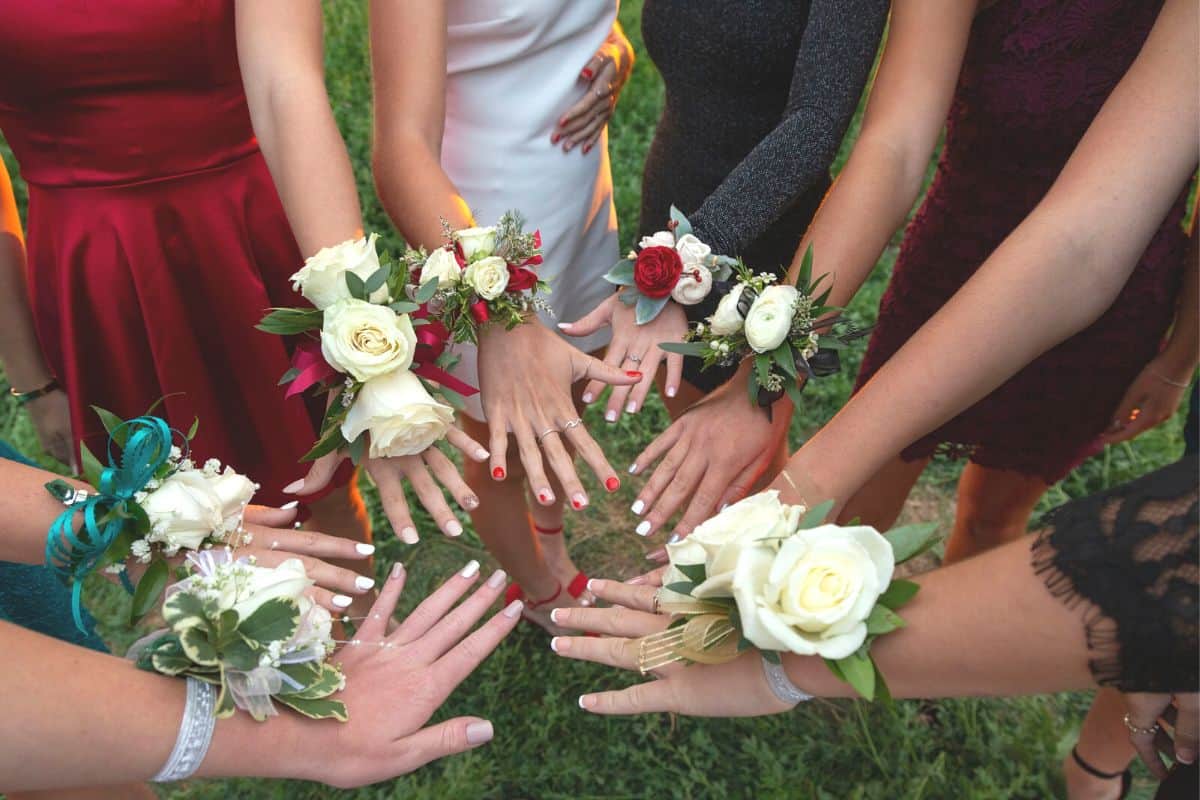 group of girls' manicured hands with corsages ready for prom