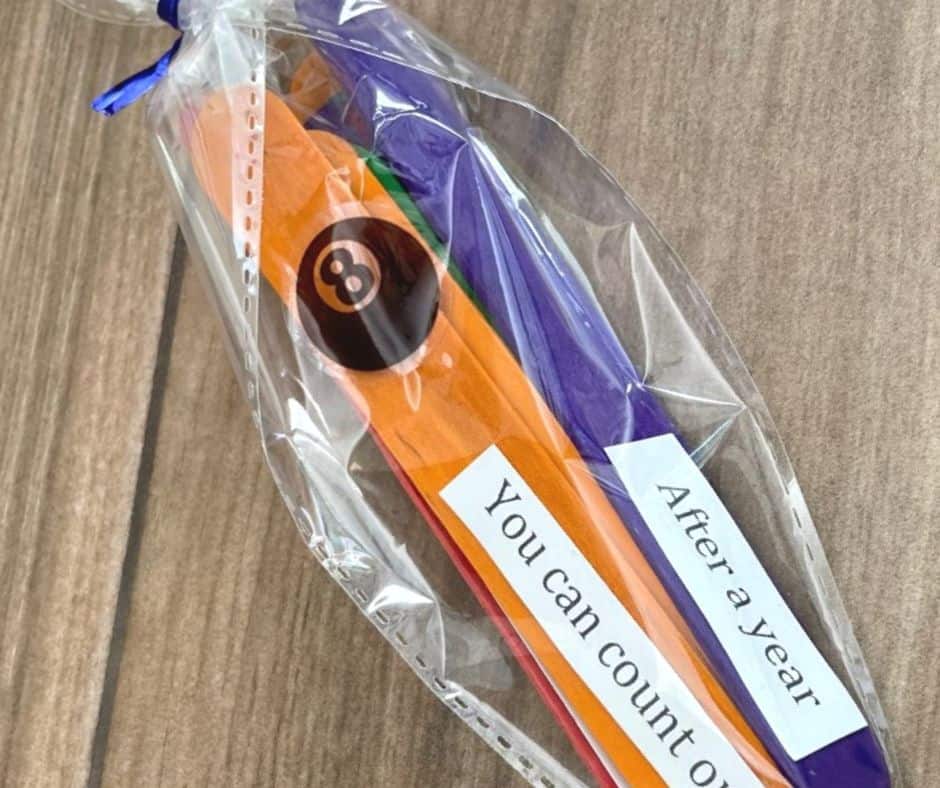 cone-shaped plastic bag with colorful popsicle sticks with sayings on them