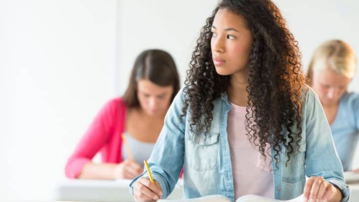 high school senior girl wearing jean shirt at desk in class