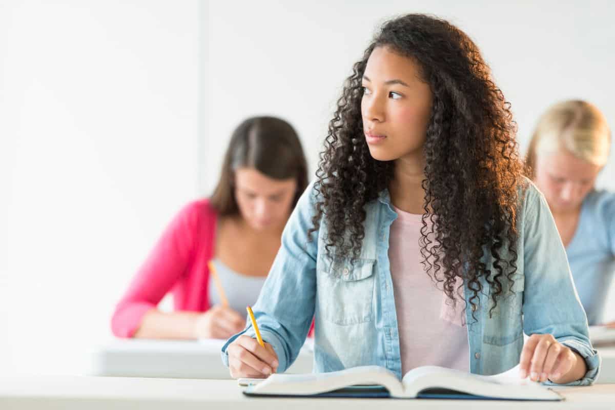 high school senior girl wearing jean shirt at desk in class