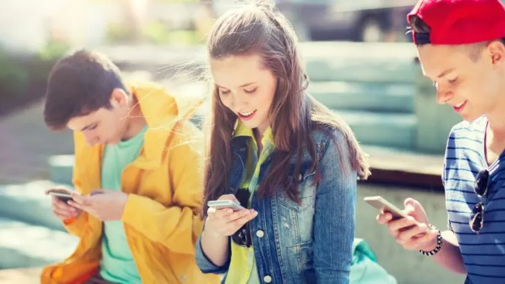 teen girl and boy on bleachers transferring money through an app