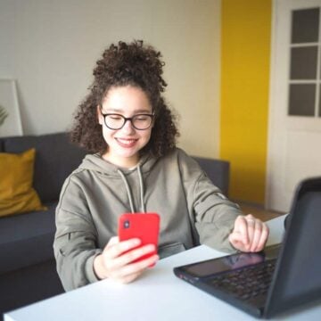 teen girl with red phone making a trade on stock app for teens