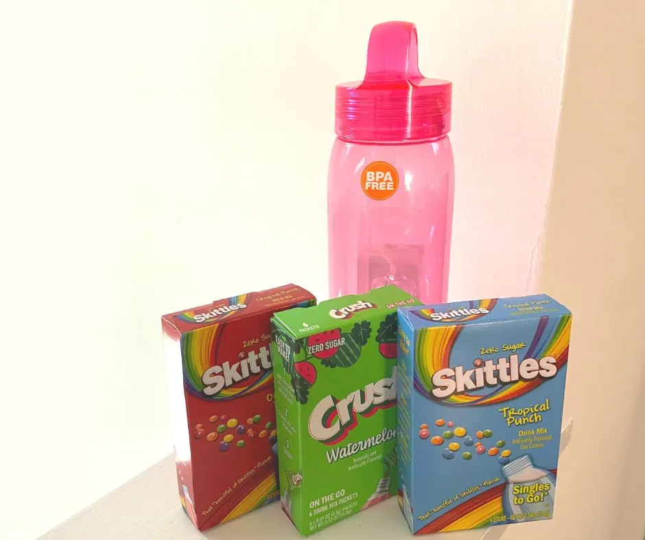 pink bpa free water bottle with three boxes of flavored drink packages in front