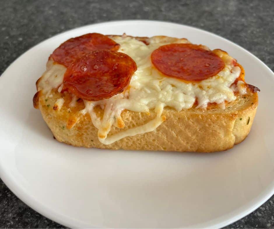 texas garlic bread toast with mozzarella and pepperoni on top on white plate