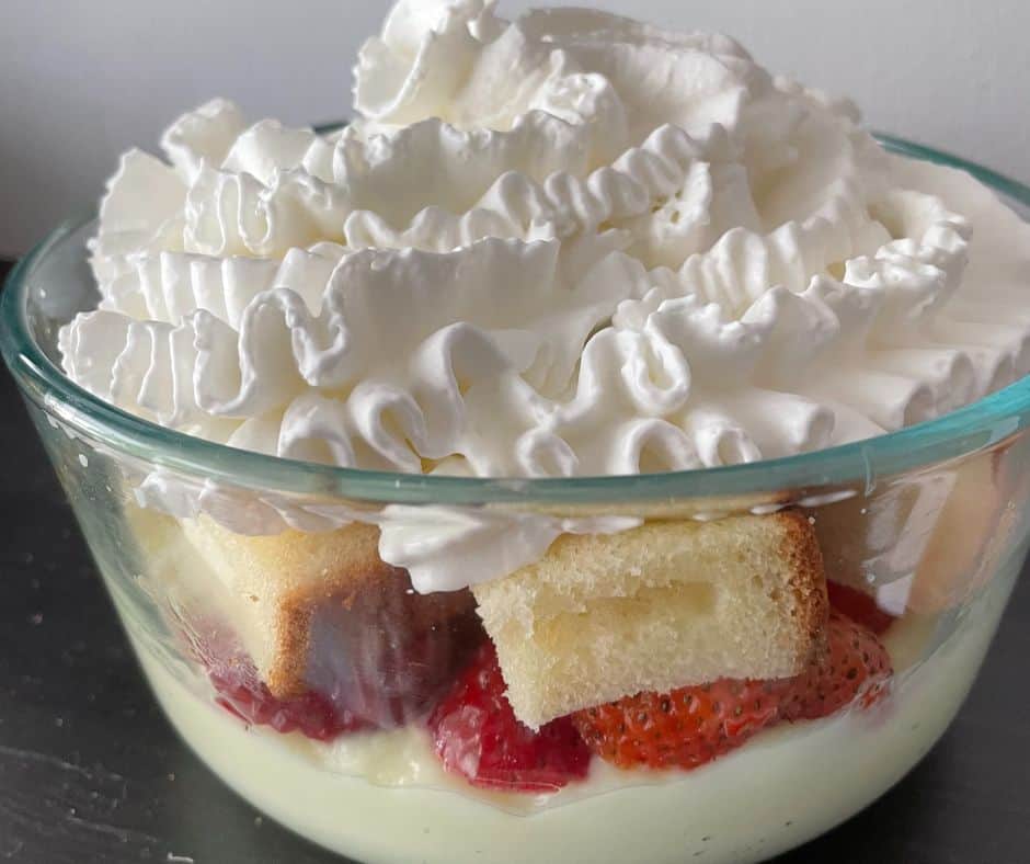 fruit, pudding, pound cake and whipped cream in glass bowl