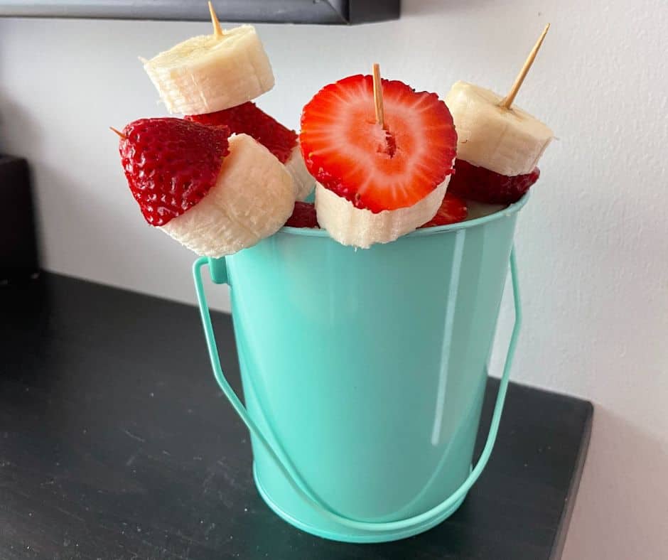 light teal metal tin with strawberry and banana kebabs